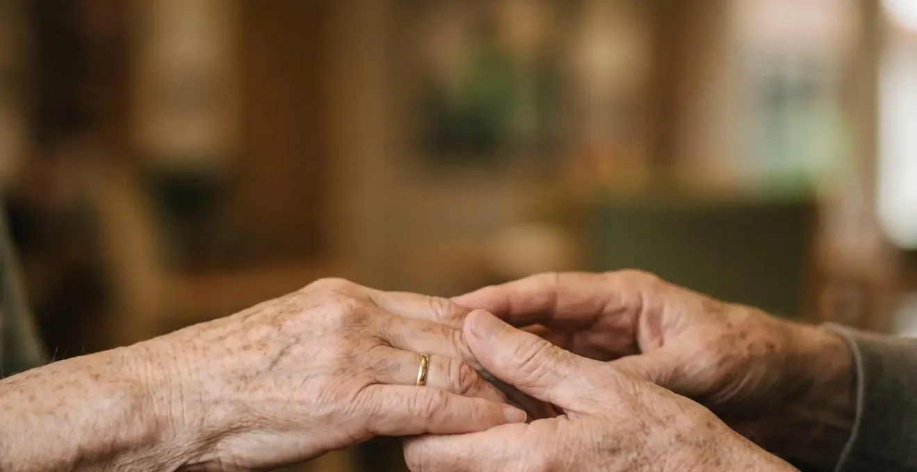 Gros plan sur des mains de seniors partageant un moment chaleureux lors d'une activité de groupe